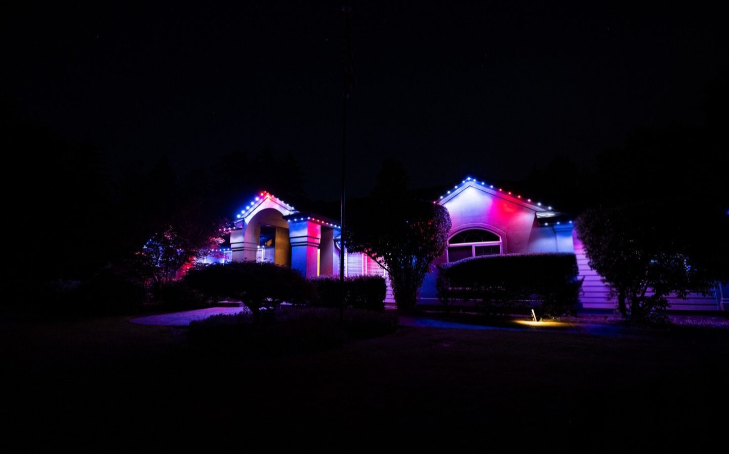 Salem home with arched entryway lit in red, white, and blue permanent LED lights with purple accent lighting