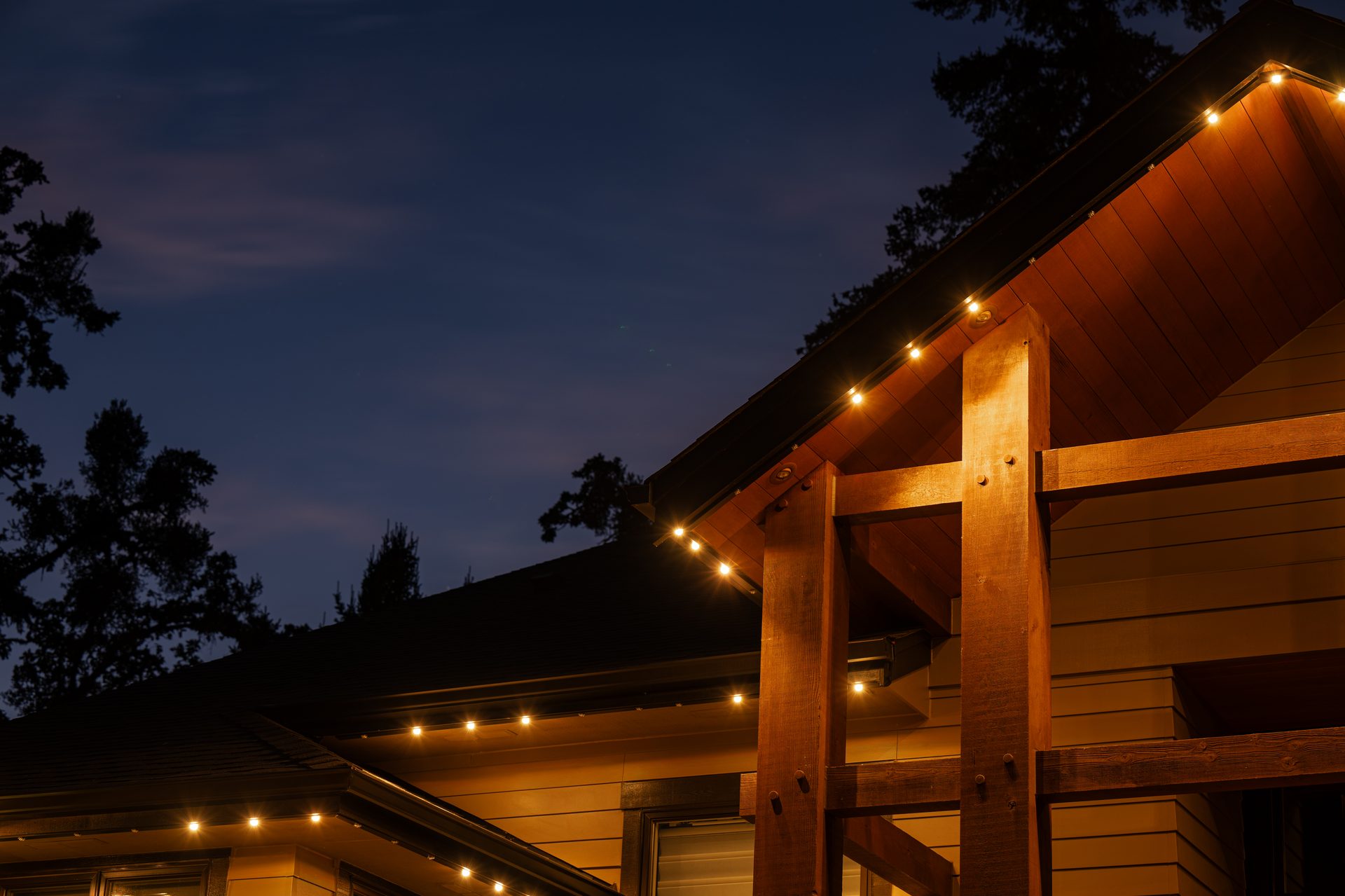 Detail shot of a Salem home's wooden beam entryway lit with warm white permanent LED lights