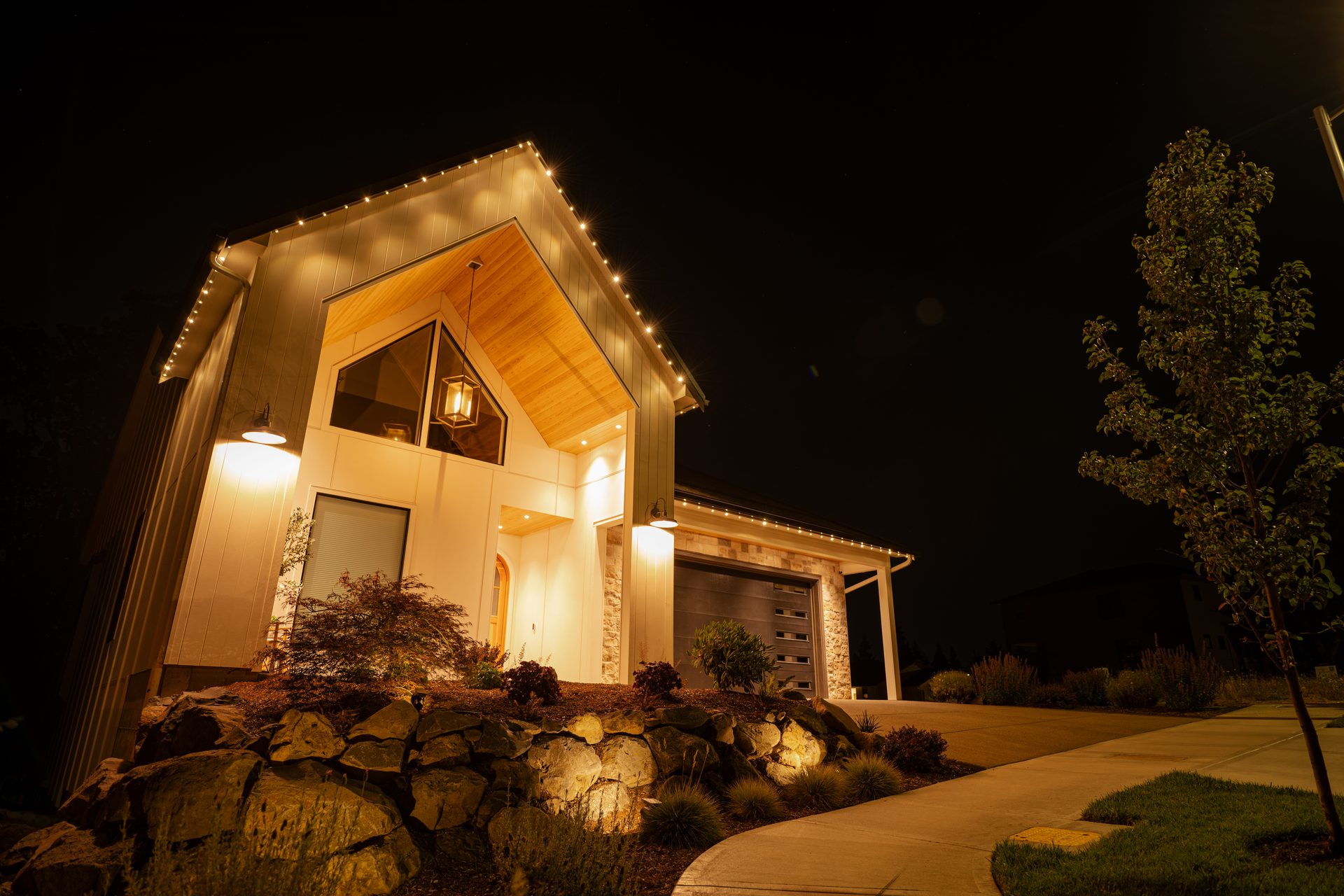 Modern farmhouse in Salem with warm white permanent LED roofline lighting at night