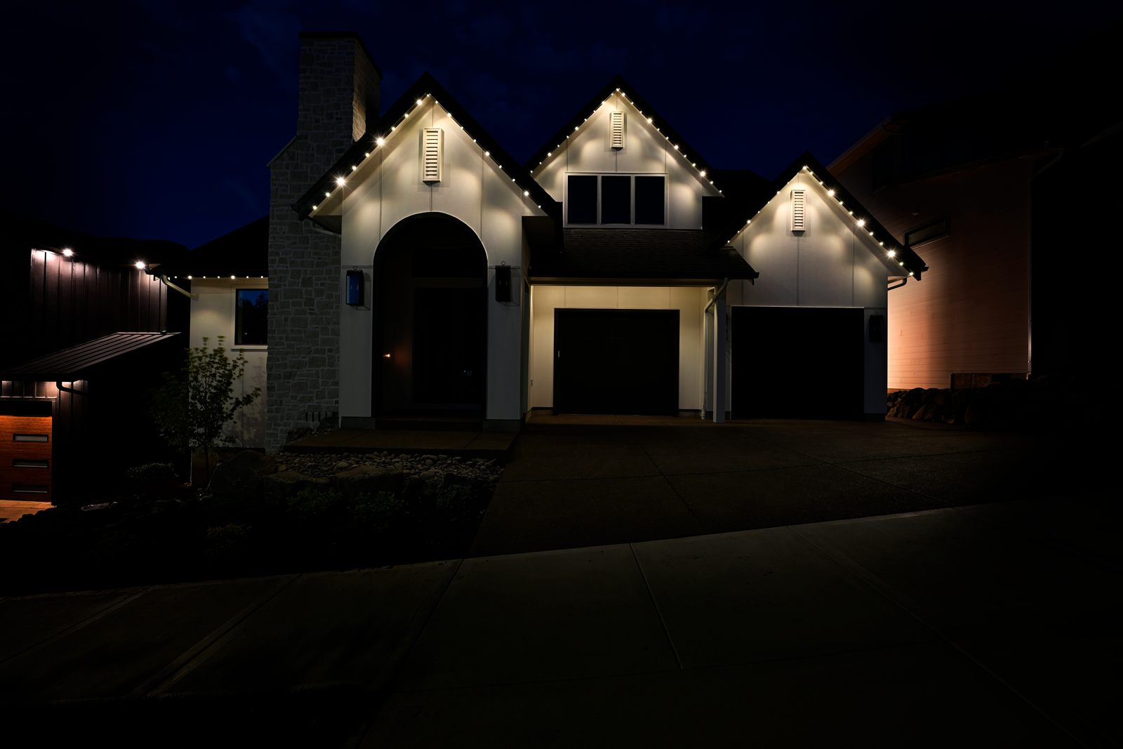 Tour of Homes 2026 featured home with warm white LED roofline lights on at night