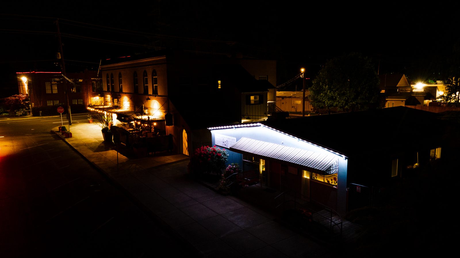Aerial drone shot of West Salem Kids Care daycare with permanent LED roofline lighting at night