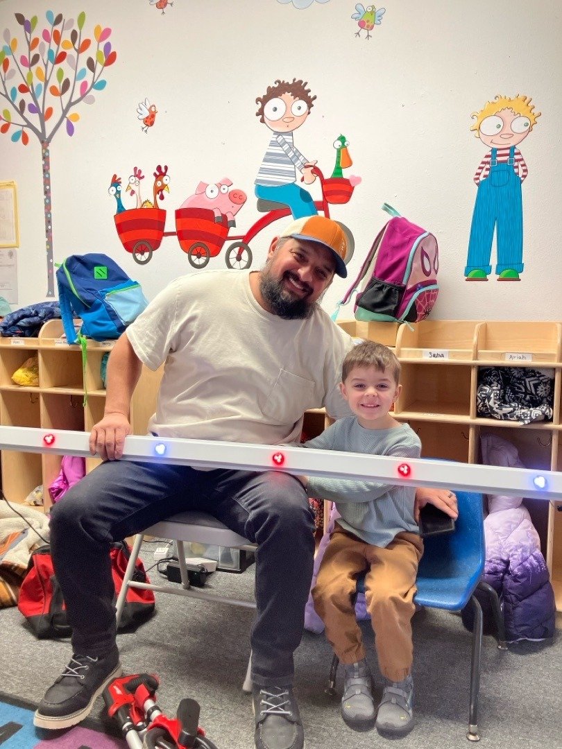 Zak Aguirre, owner of Timber Glow Lights, holding an InvisiLights LED track with his son in Salem Oregon